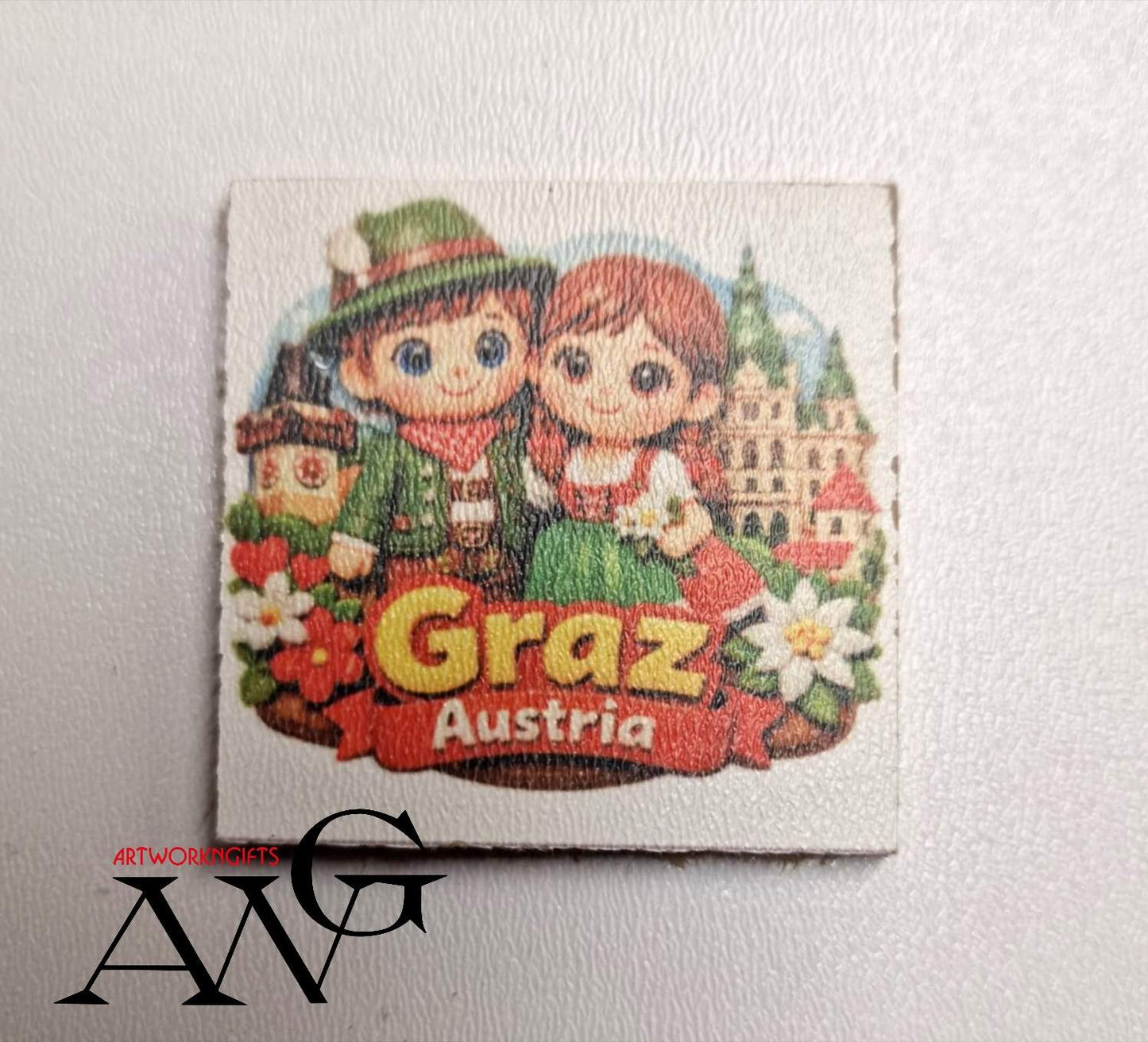cartoon illustration of a couple in traditional Austrian clothing against a backdrop of the city of Graz. Handmade wooden fridge magnet 5×5 cm